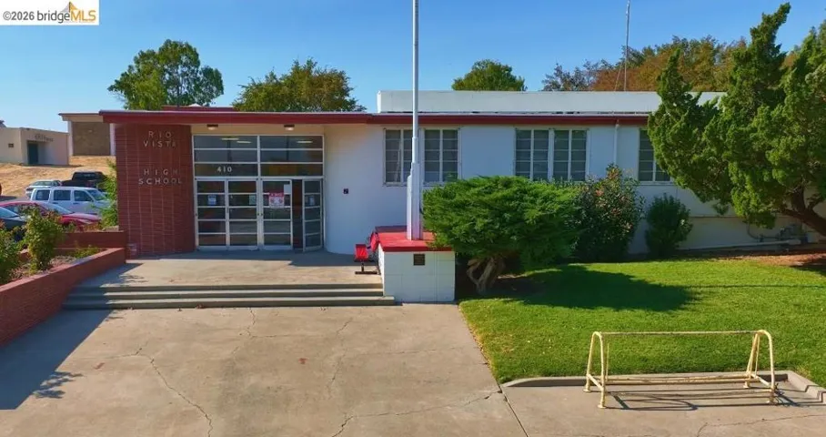 View of front facade featuring a front lawn, stucco siding, and a patio