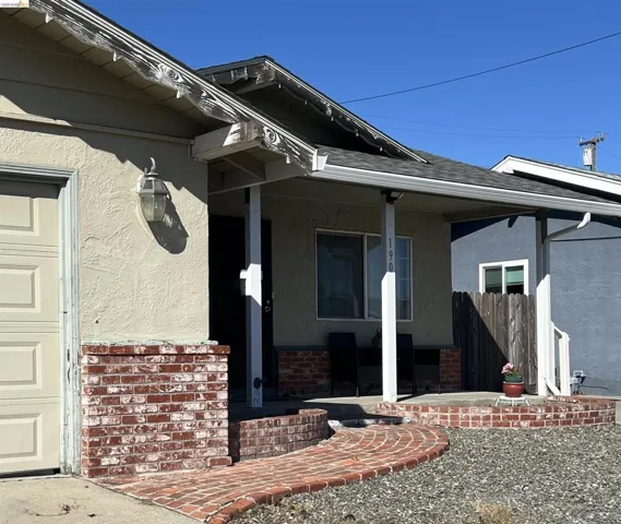 Entrance to property featuring stucco siding, a porch, a garage, and a shingled roof