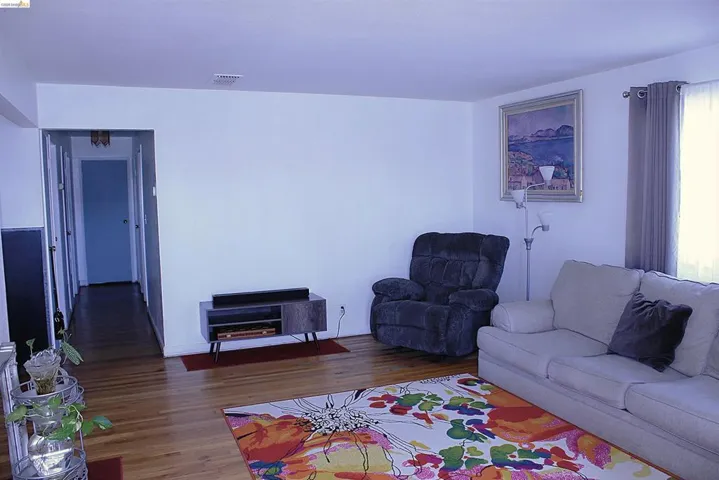 Living room with dark wood-type flooring