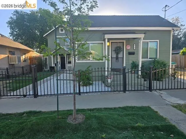 Bungalow featuring a fenced front yard and a gate