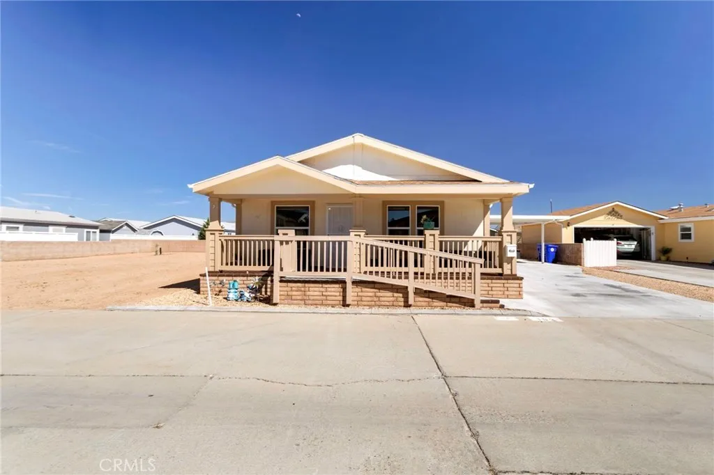 Front exterior with covered porch, ramp and  large driveway.