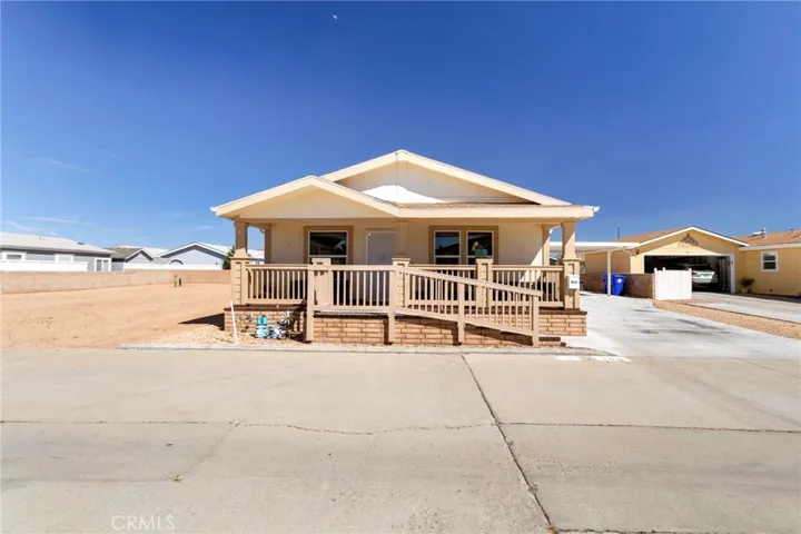 Front exterior with covered porch, ramp and  large driveway.