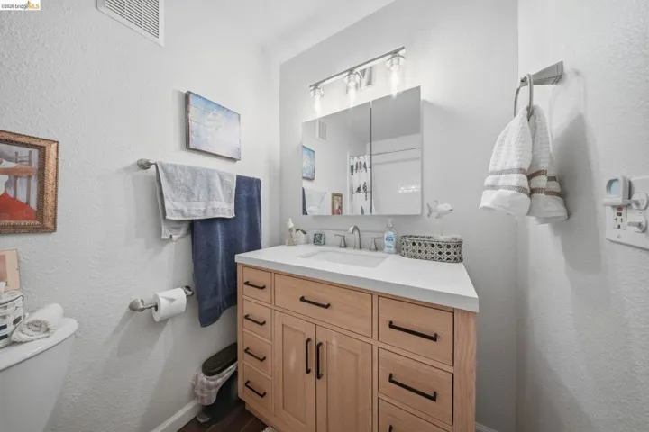 Bathroom with a textured wall, vanity, and a shower with curtain