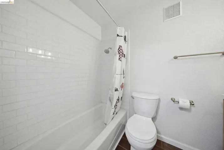 Full bathroom with baseboards and shower / tub combo with curtain