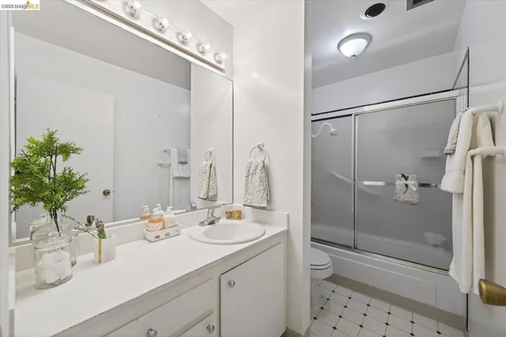 bathroom with vanity, bath / shower combo with glass door, and light flooring