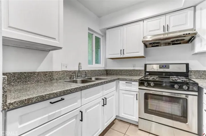 Brand new kitchen appliances, countertops, stove, and fridge with light natural tones.
