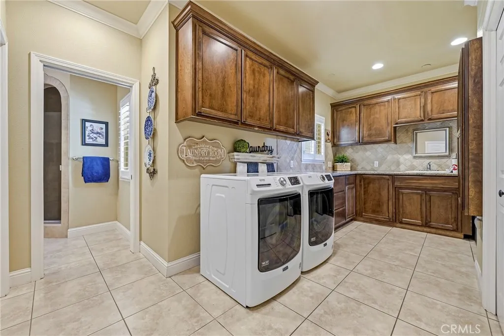 Laundry & mud room with view into third full bathroom