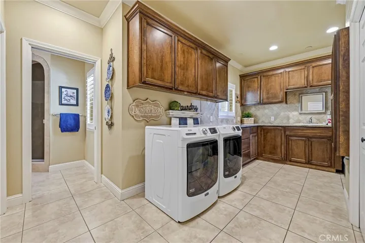 Laundry & mud room with view into third full bathroom