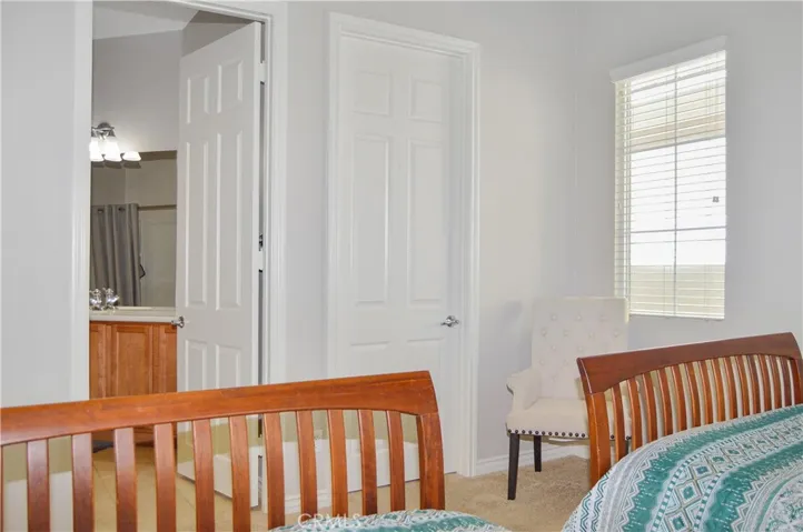 2nd bedroom with direct access to 2nd full bath, spacious walk-in closet, white window blinds, cozy carpet, & pre-wired for an overhead light.