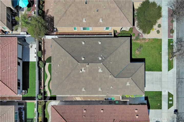 Drone view showing easy-care yard and tile roof