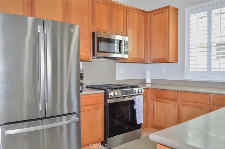 Well-equipped kitchen with BRAND NEW appliances in 2026 (Refrigerator, range, microwave & dishwasher), new faucet, louvered shutters, and Corian-style seamless countertops and back splash