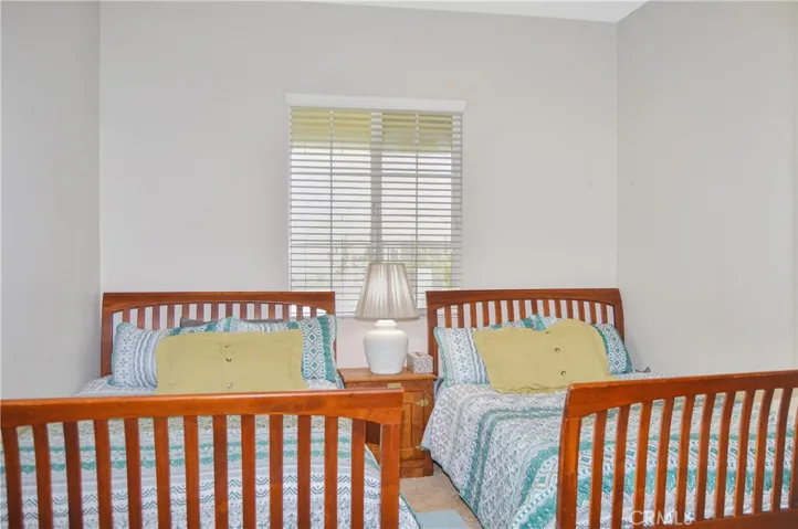 2nd bedroom with direct access to 2nd full bath, spacious walk-in closet, white window blinds, cozy carpet, & pre-wired for an overhead light.