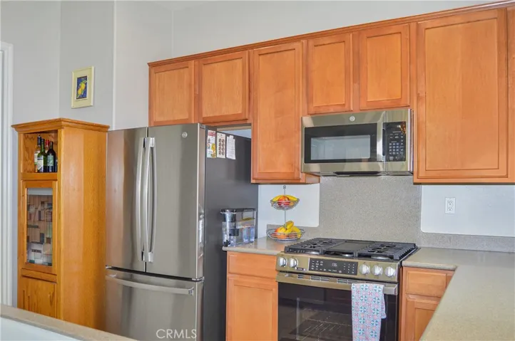Well-equipped kitchen with BRAND NEW appliances in 2026 (Refrigerator, range, microwave & dishwasher), new faucet, louvered shutters, and Corian-style seamless countertops and back splash