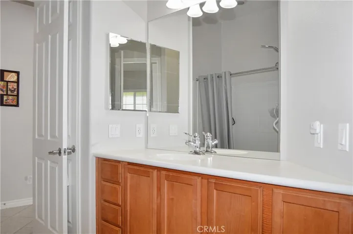 2nd bath - accessed from 2nd bedroom or hallway offers extra-tall dual shower heads in the shower/tub combo, handy linen closet, oversized white Corian-style vanity, and tile flooring