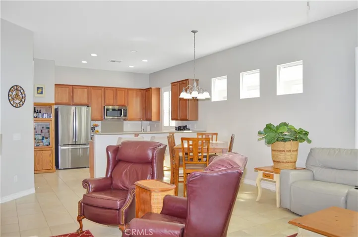 The great room offers the open floor plan living you desire with a cozy fireplace, louvered shutters, tile flooring, ceiling fan, and easy access to the covered patio out back. TV image added virtually.