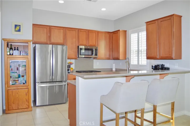Well-equipped kitchen with BRAND NEW appliances in 2026 (Refrigerator, range, microwave & dishwasher), new faucet, louvered shutters, and Corian-style seamless countertops and back splash