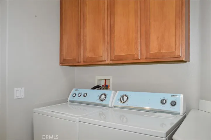 Convenient laundry room between kitchen and garage with washer and dryer included, linen storage, handy sink and tile floor