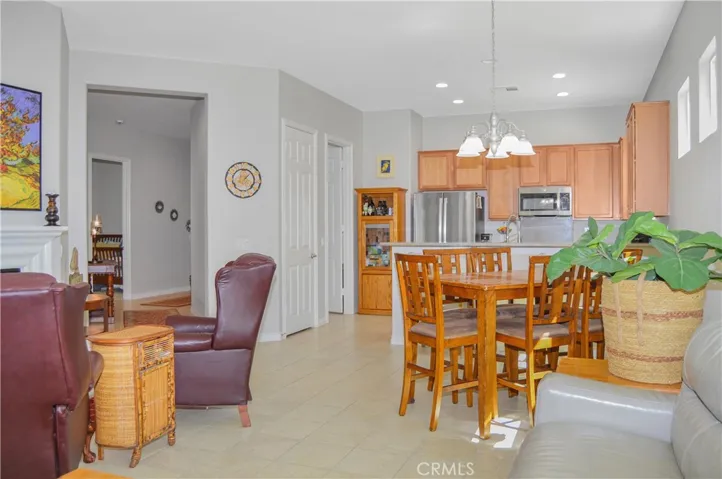 The great room offers the open floor plan living you desire with a cozy fireplace, louvered shutters, tile flooring, ceiling fan, and easy access to the covered patio out back.