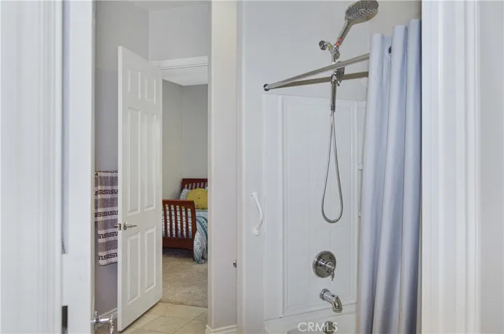 2nd bath - accessed from 2nd bedroom or hallway offers extra-tall dual shower heads in the shower/tub combo, handy linen closet, oversized white Corian-style vanity, and tile flooring