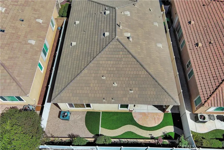 Drone view showing easy-care yard and tile roof