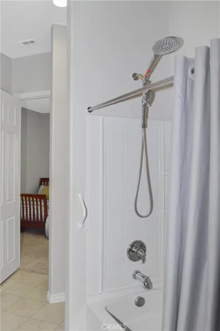 2nd bath - accessed from 2nd bedroom or hallway offers extra-tall dual shower heads in the shower/tub combo, handy linen closet, oversized white Corian-style vanity, and tile flooring