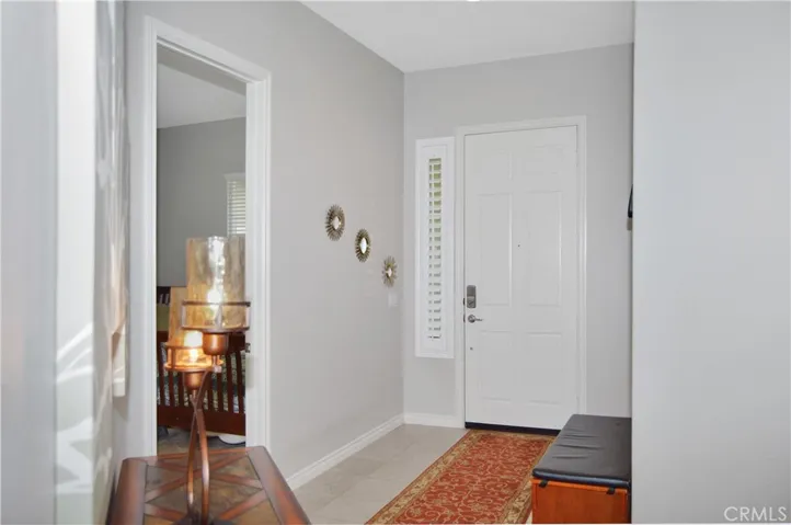 Inviting entry with louvered shutters and tile flooring - which continues throughout most of this welcoming home (the bedrooms and dens have cozy carpet instead)