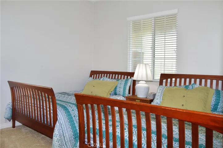 2nd bedroom with direct access to 2nd full bath, spacious walk-in closet, white window blinds, cozy carpet, & pre-wired for an overhead light.