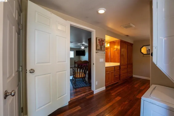 Laundry area with washer / dryer, dark wood-style flooring, ceiling fan, and recessed lighting