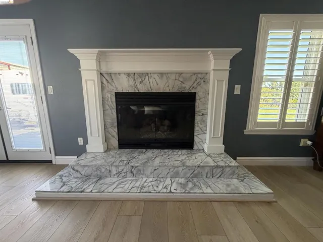 Detailed view of wood finished floors and a high end fireplace