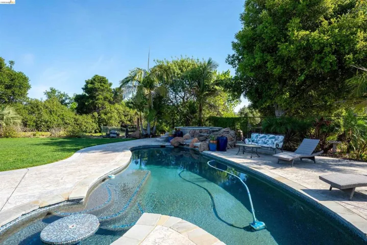 Outdoor pool with a patio, a fenced backyard, and an outdoor hangout area