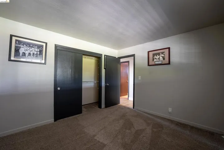 Unfurnished bedroom featuring a closet and light carpet
