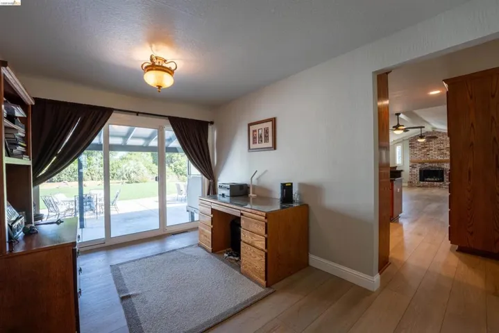 Office space featuring a fireplace, light wood-type flooring, and plenty of natural light