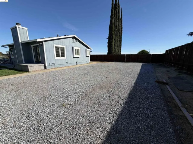 View of home's exterior with a fenced backyard and a chimney