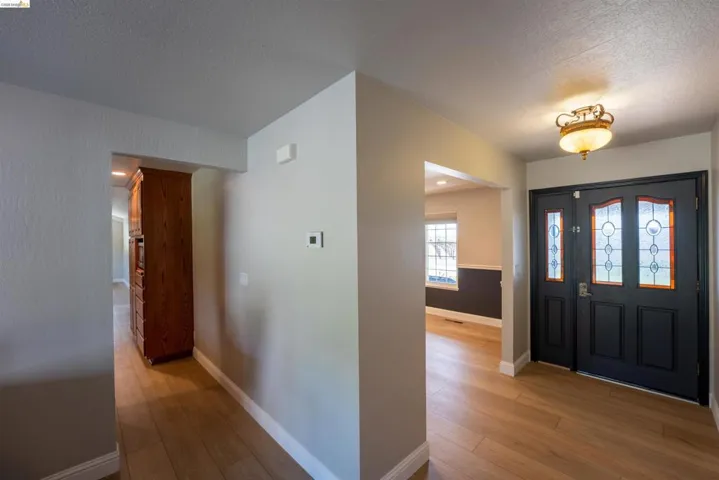 Foyer entrance with light wood finished floors and a textured ceiling
