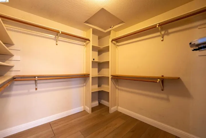 Walk in closet featuring attic access and light wood-type flooring
