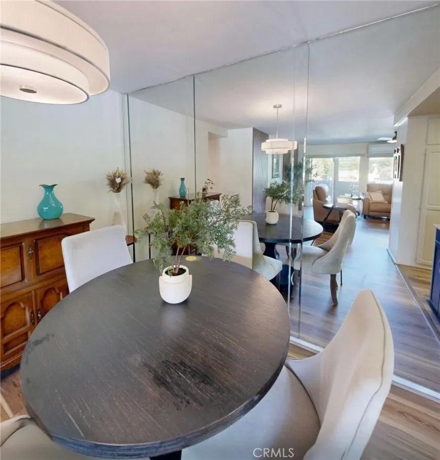 Elegant dining area just off the kitchen featuring a mirrored beveled wall that reflects light and creates a spacious feel, seamlessly open to the living room for easy entertaining.