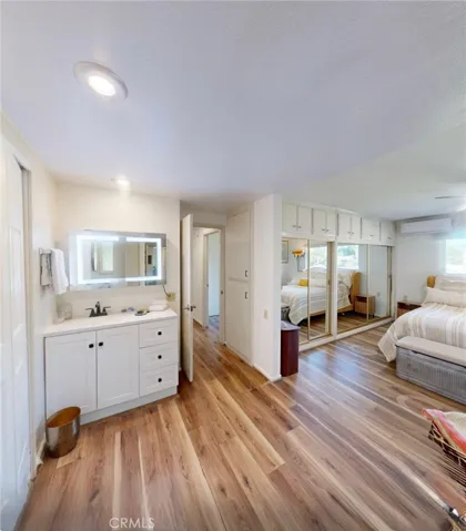 Thoughtfully designed primary suite entrance with a lighted vanity, built-in cabinetry, and additional closet storage along the wall, creating a functional and organized dressing space.