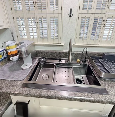 Entertain with ease at this upgraded kitchen prep station, featuring a workstation sink with integrated accessories, bartender-style glass rinser, produce rinse waterfall, pull-out faucet, and reverse osmosis drinking water.