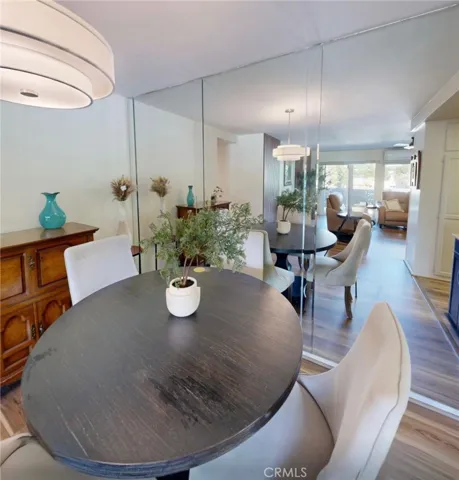 Elegant dining area just off the kitchen featuring a mirrored beveled wall that reflects light and creates a spacious feel, seamlessly open to the living room for easy entertaining.