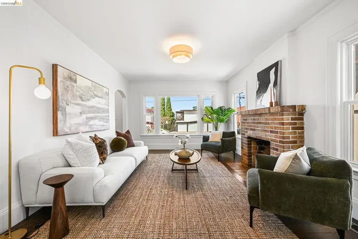 Living room featuring wood finished floors, a fireplace, and ornamental molding