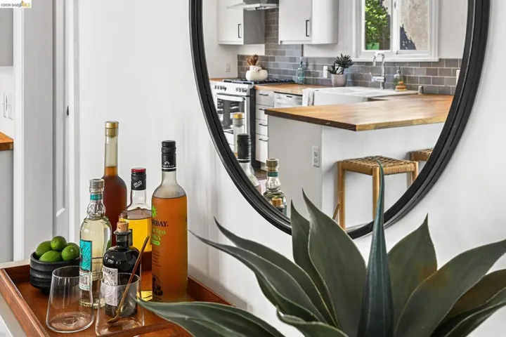 Bar area featuring wooden counters, white cabinets, and decorative backsplash
