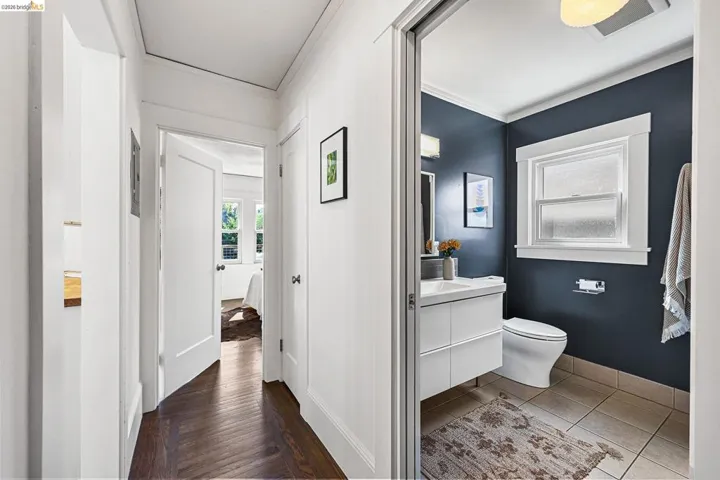 Bathroom with vanity, crown molding, and light wood finished floors