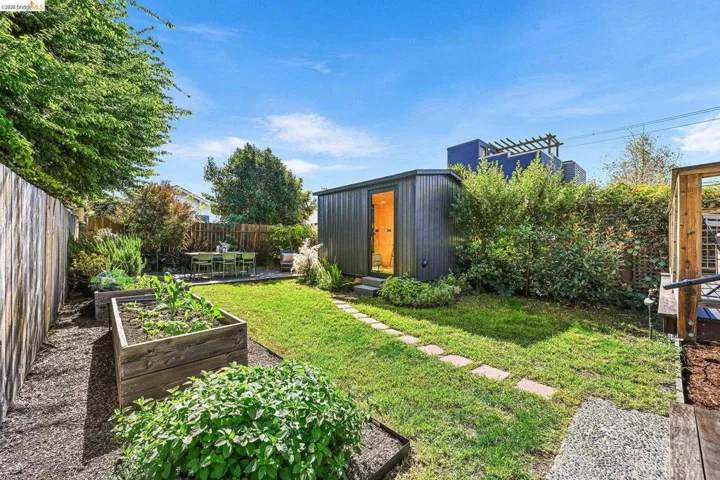 Fenced backyard featuring a vegetable garden, an ADU, and outdoor dining space