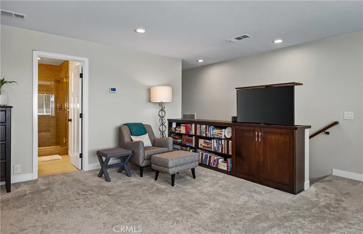 Primary bedroom lounge or reading area - this TV    remotely stores away in the custom cabinetry