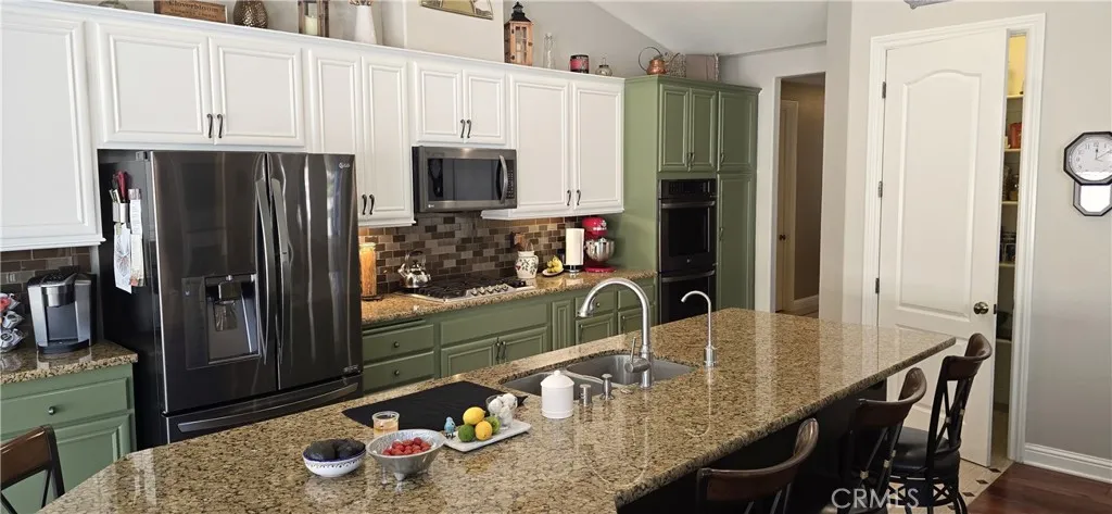 Black stainless steel appliances. Walk in pantry