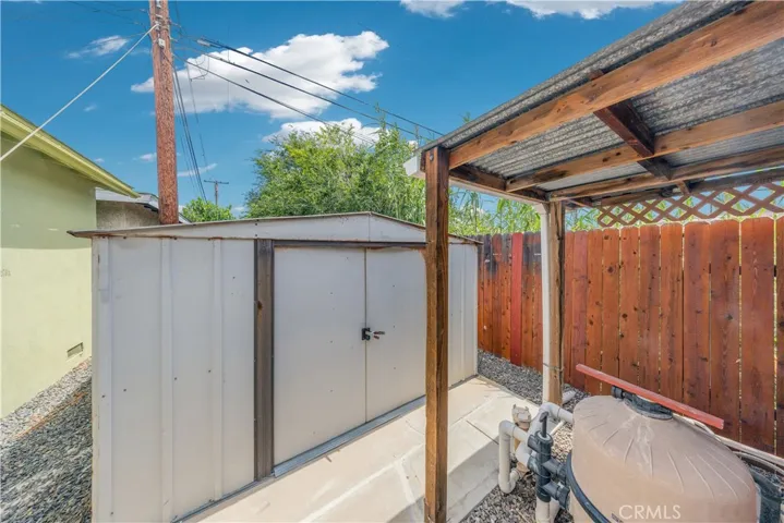 on the other side of the gate is another shed for storage and the pool equipment