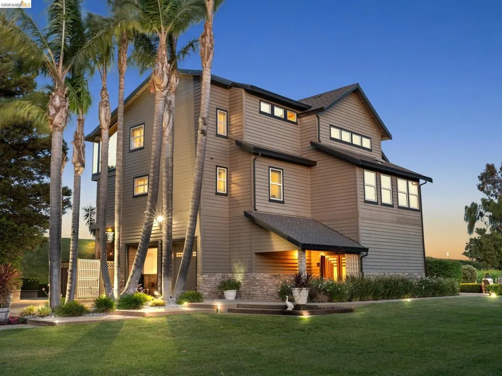 View of front of home with a front yard and stone siding