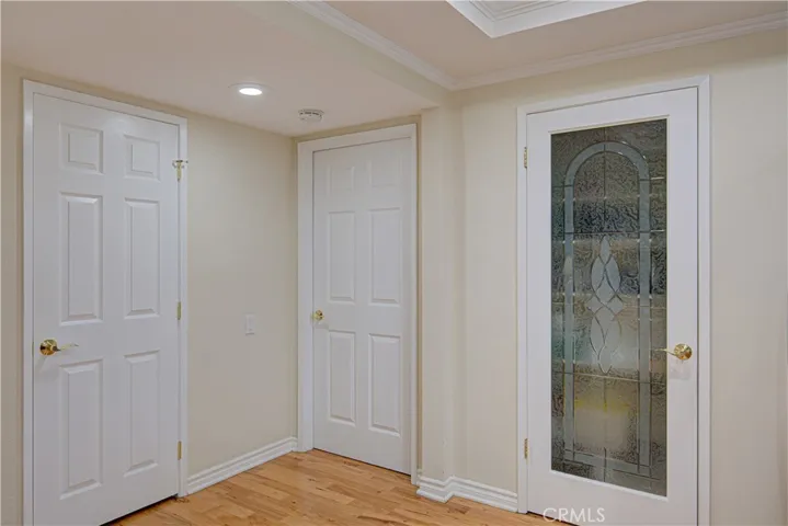 Open concept from the kitchen showing the leaded Pantry glass door Closed, to the left of it is the entrance to the Primary Bedroom and the other door is a hall closet.