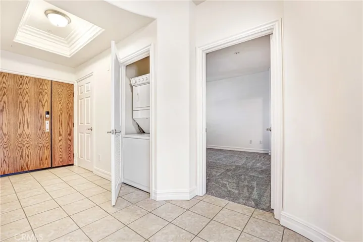 Foyer entry with view of stackable laundry closet.