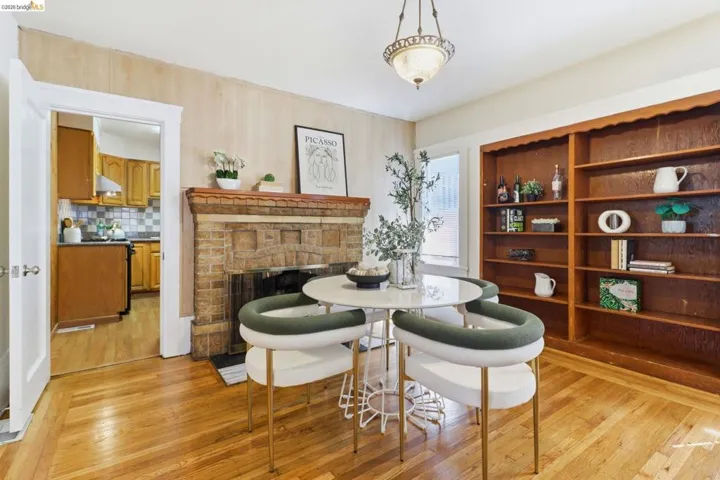Dining room with light wood-style floors and a stone fireplace